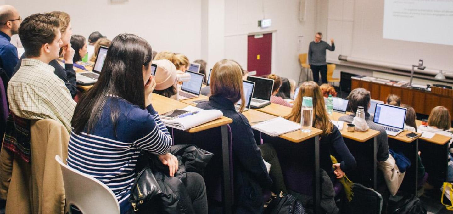 A group of students attending a lecture in a lecture theatre