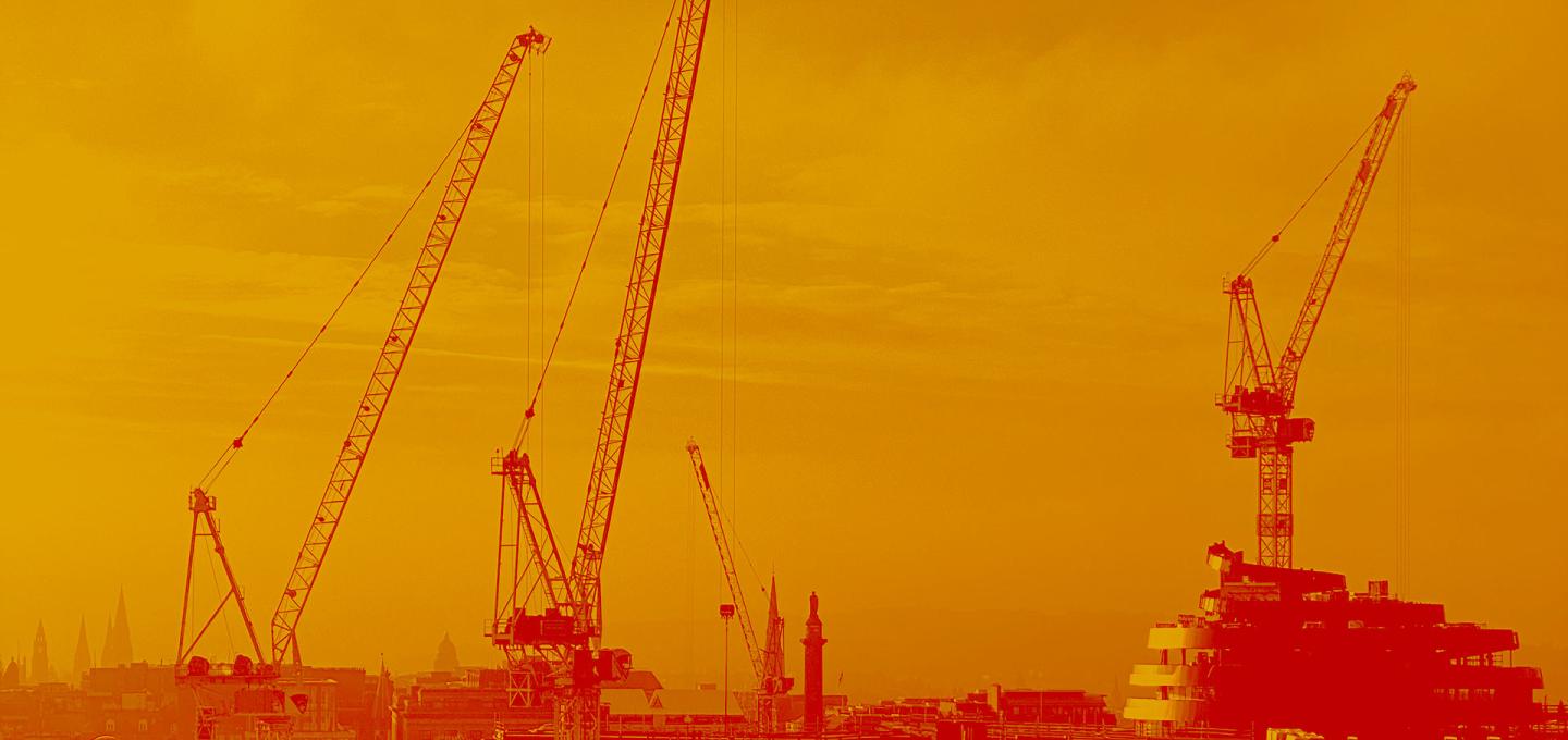 A view of the Edinburgh skyline coloured in orange and red. Four cranes and the walnut whip shape of the W hotel can be seen above the roof tops.