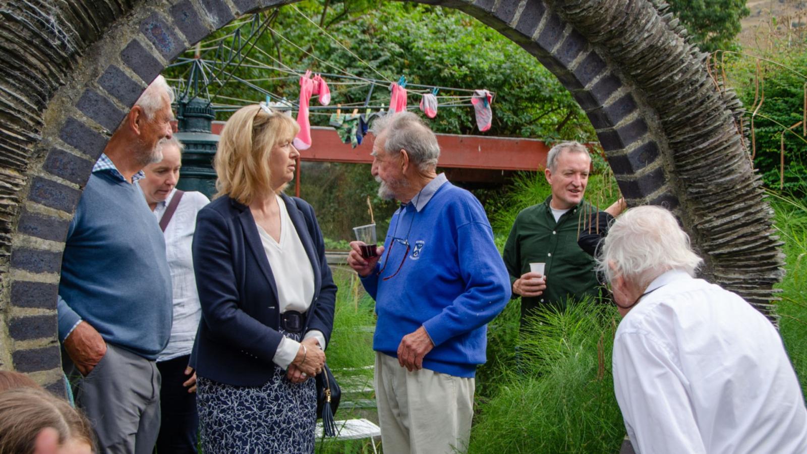 People gathered by a stone archway