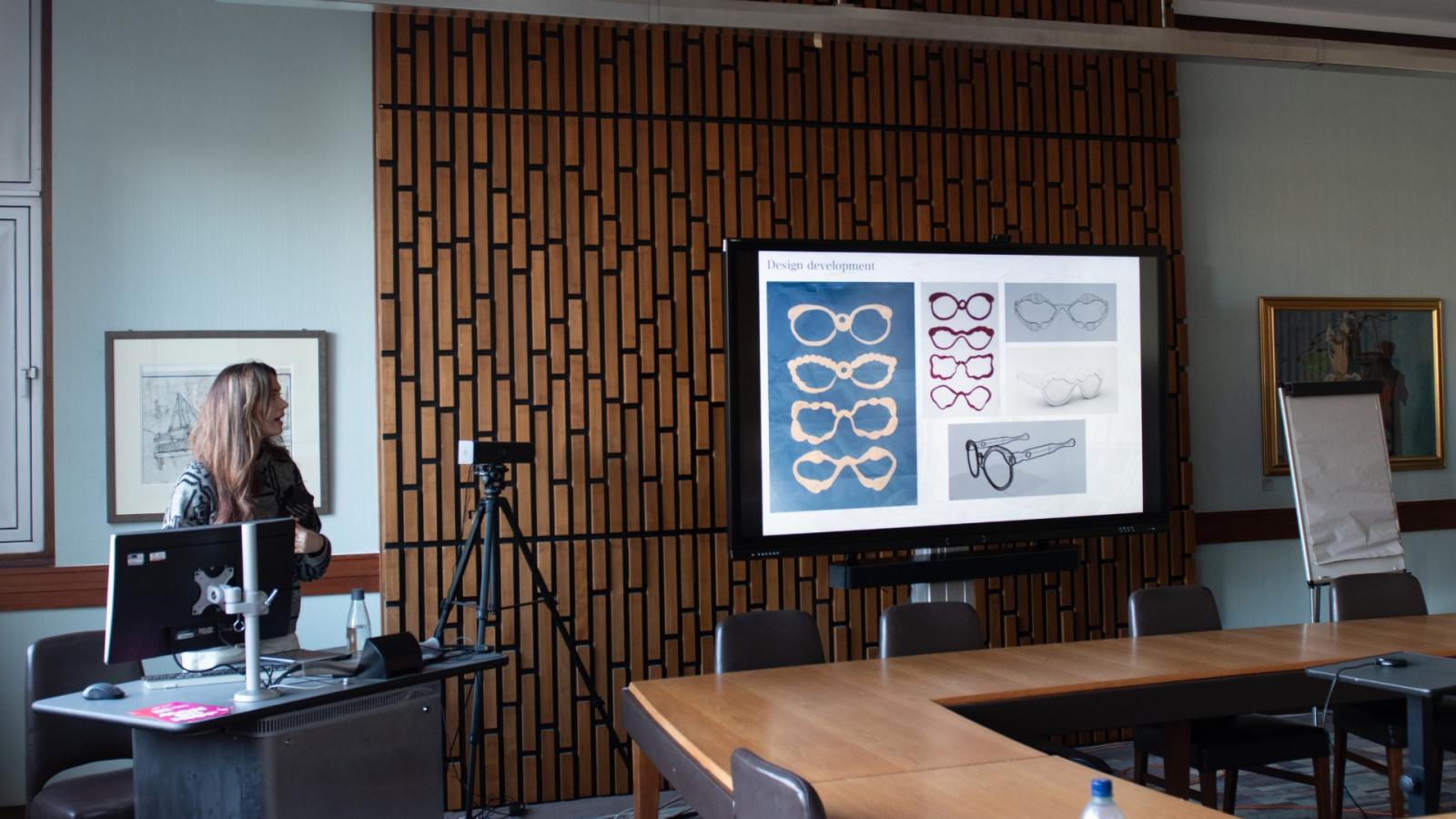 A photo of Holly presenting ideas on a projector.