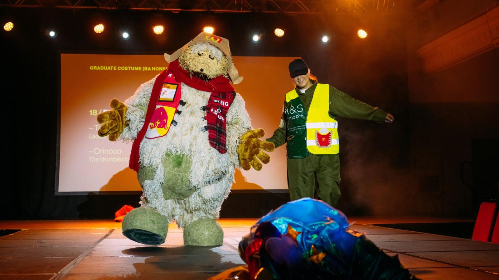 A photo of Orinoco from the Wombles costume on stage at the Performance Costume Show 2023, led by designer Biz Sutton