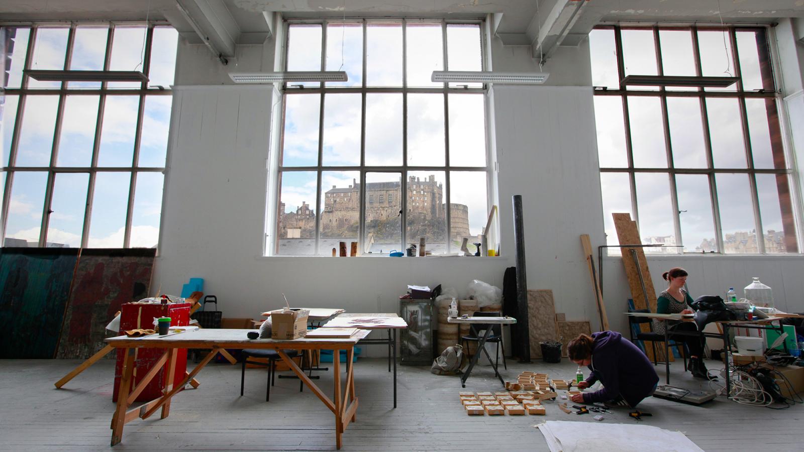 Students working in one of ECA's painting studios, with views of the castle seen through the large windows.