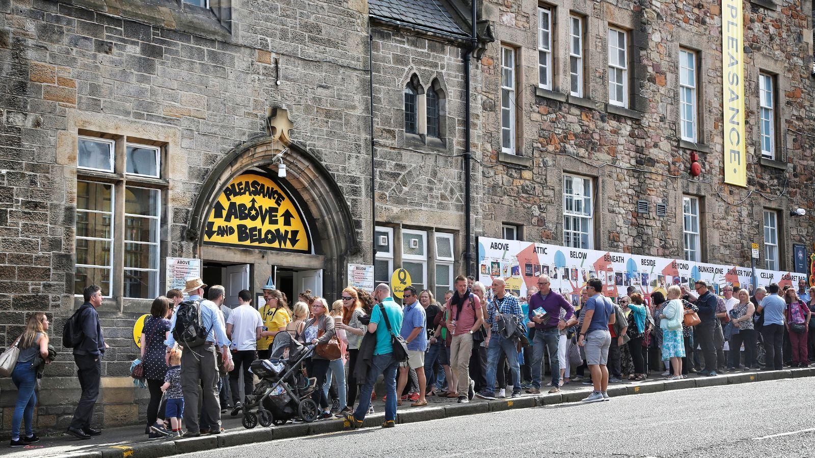 A line of people, queuing outside The Pleasance, during the Fringe 