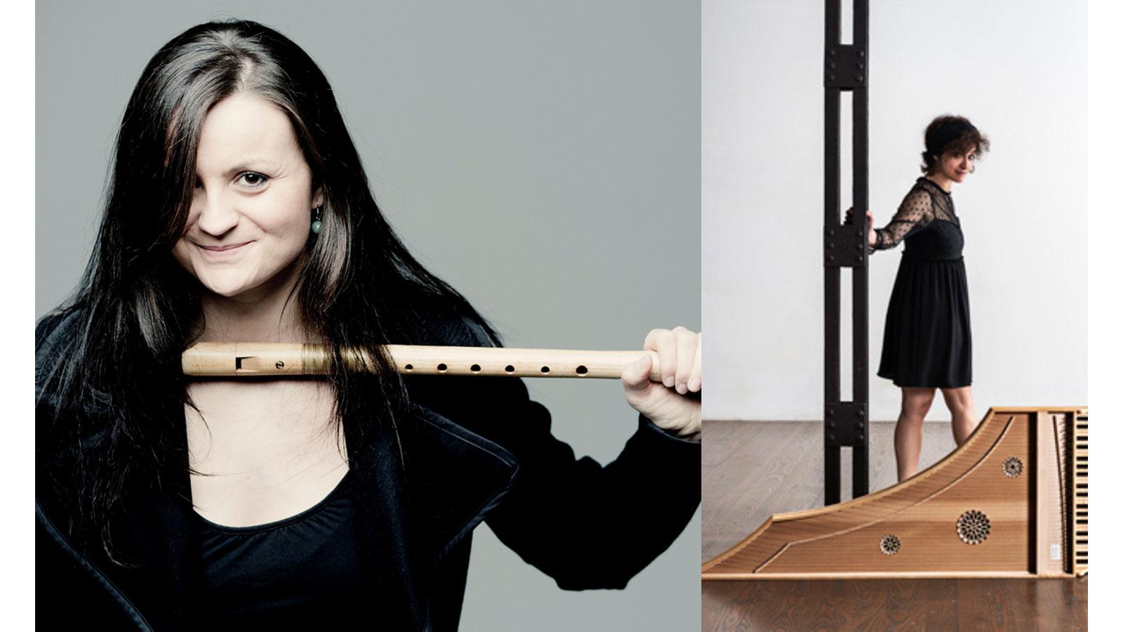 Two musicians, one holds their recorder and smiles to the camera, the other walks to a harpsichord that's lying on its side.