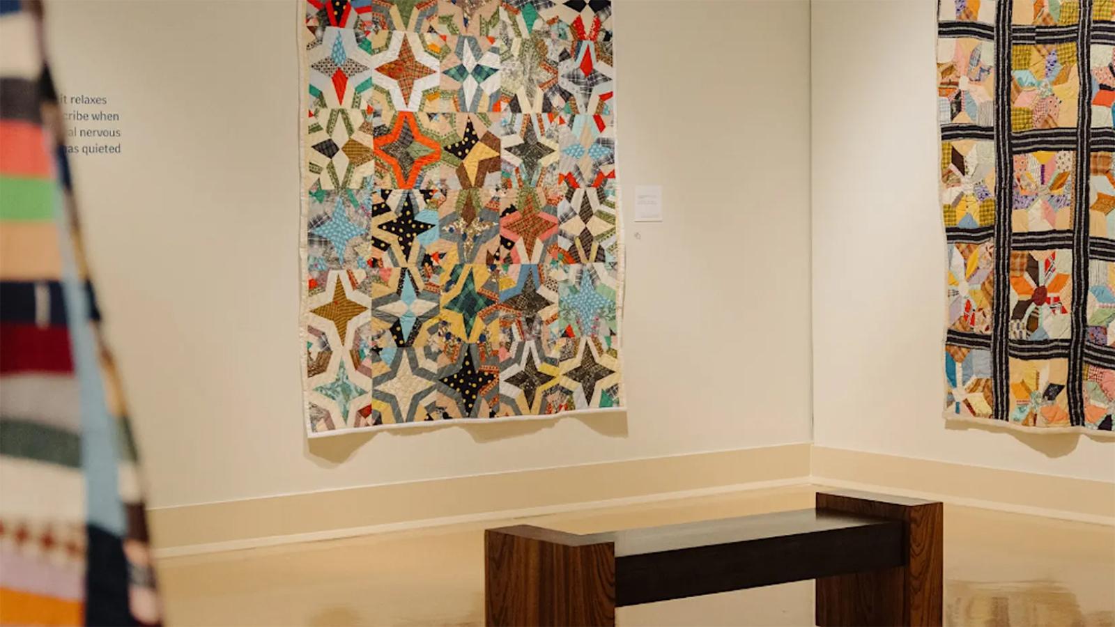 A corner of the exhibition, Of Salt and Spirit: Black Quilters in the American South, Mississippi Museum of Art 2025, featuring two quilted pieces of work.