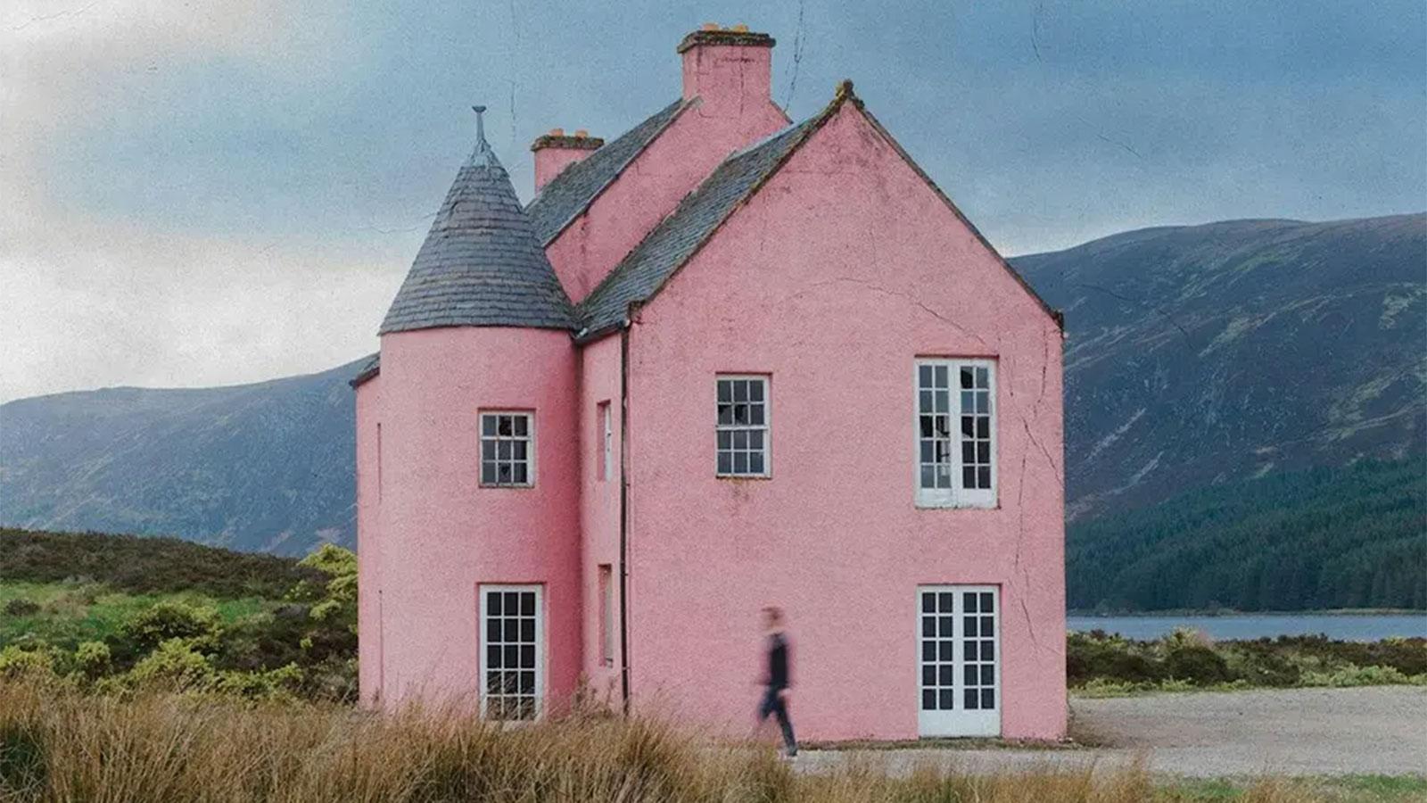 Composer Gareth Williams walking past the pink house at Loch Glass, Scotland.