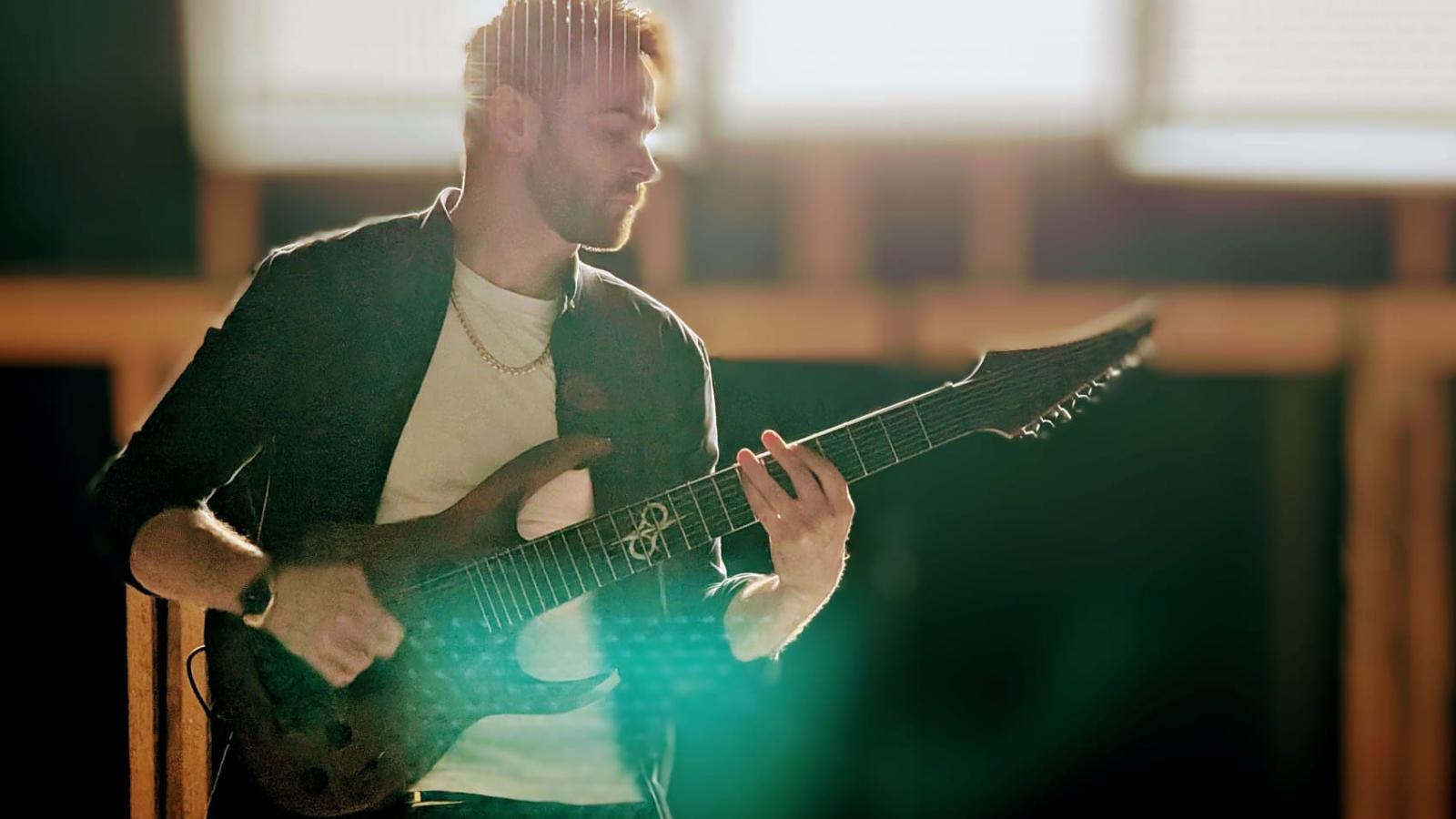 Fraser plays a guitar whilst filming for a music video.