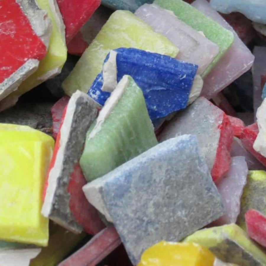 A close-up of mosaic tiles of various colours including yellow, red and blue in a clear plastic bag