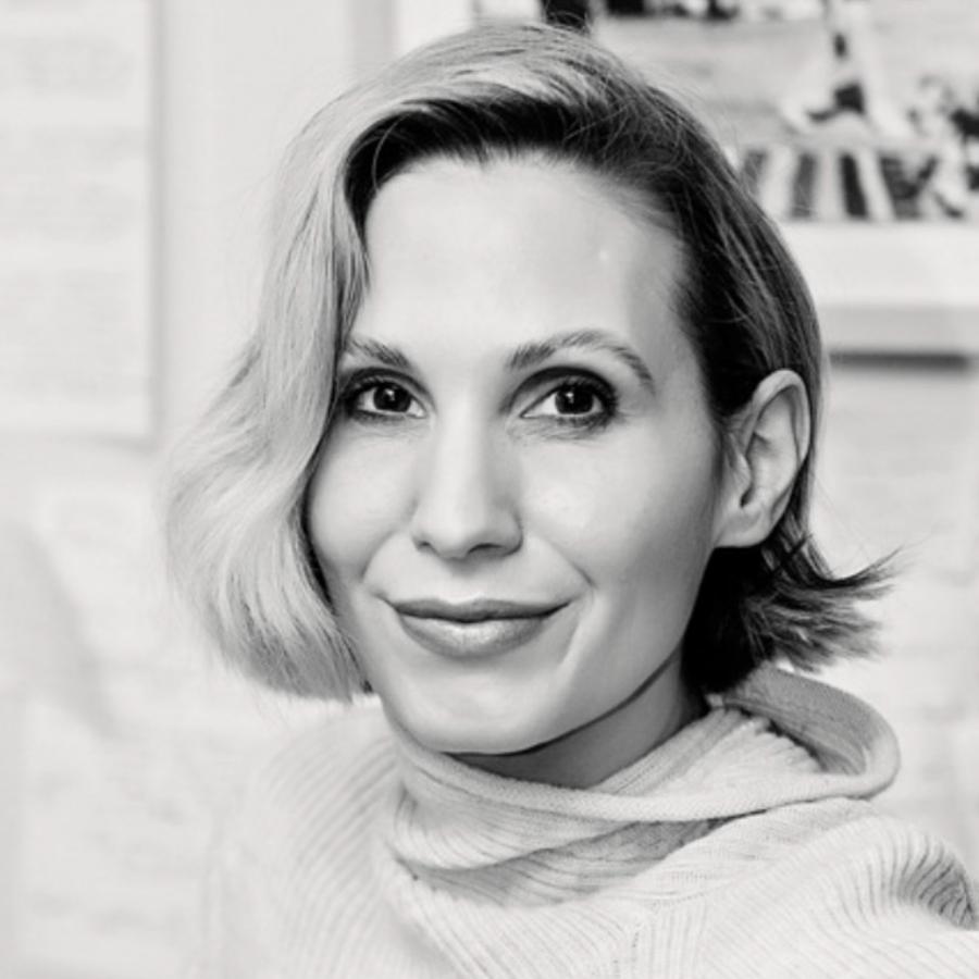 A black and white photo of a person with short hair swept to the side, and a roll neck jumper on.