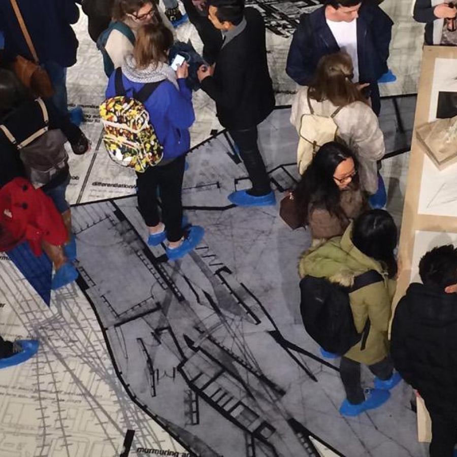 A view from above of various people gathering around tables which feature projects and works on display