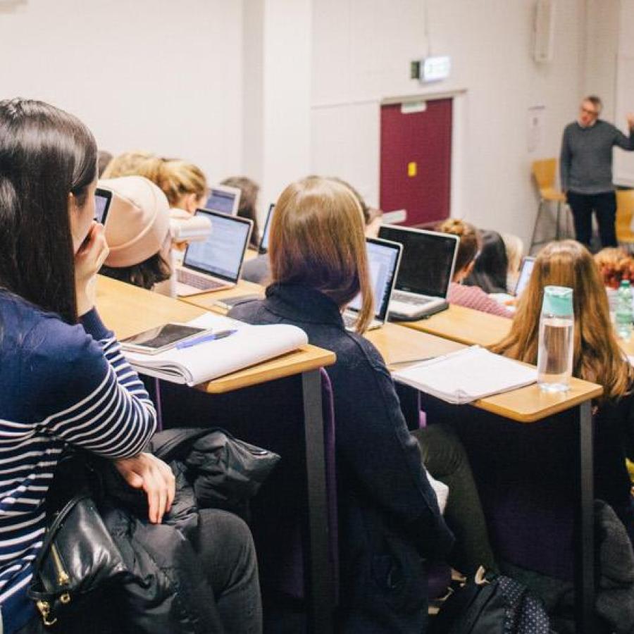 A group of students attending a lecture in a lecture theatre