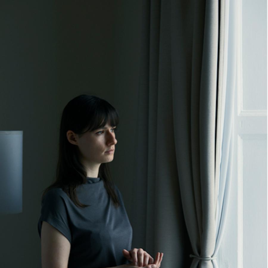 Photograph of someone looking out a window