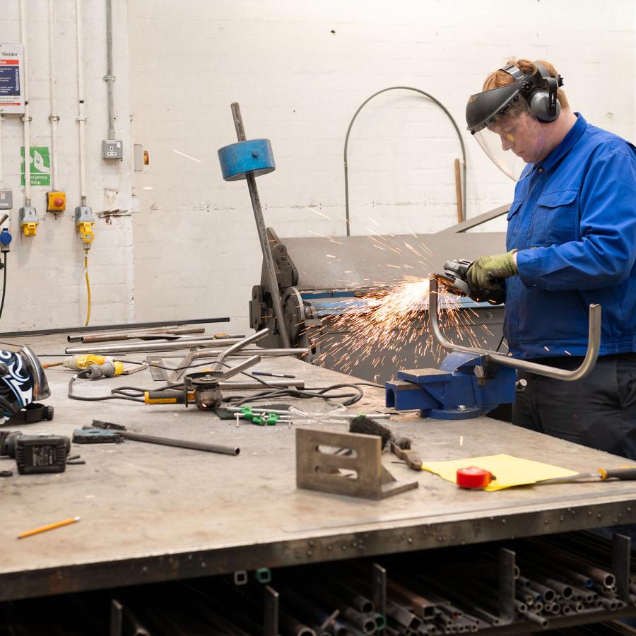 A person welding metal in the metal workshop
