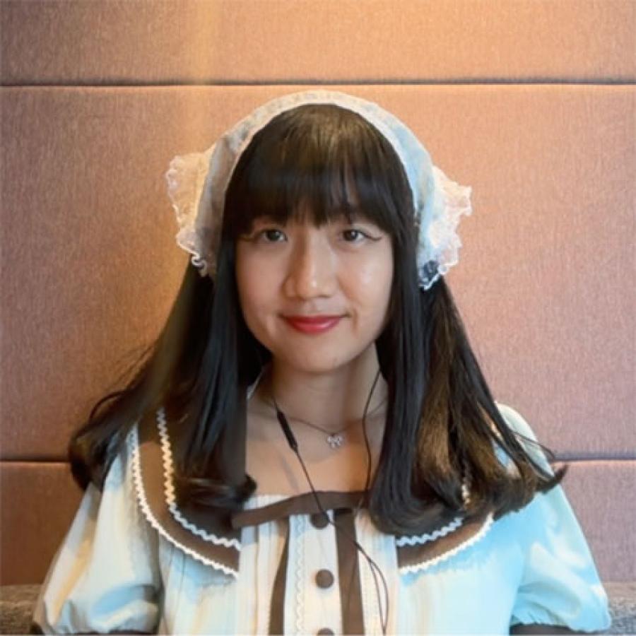 Novia wears a lace bandana, a white shirt with a peter pan-style collar and brown button detail.