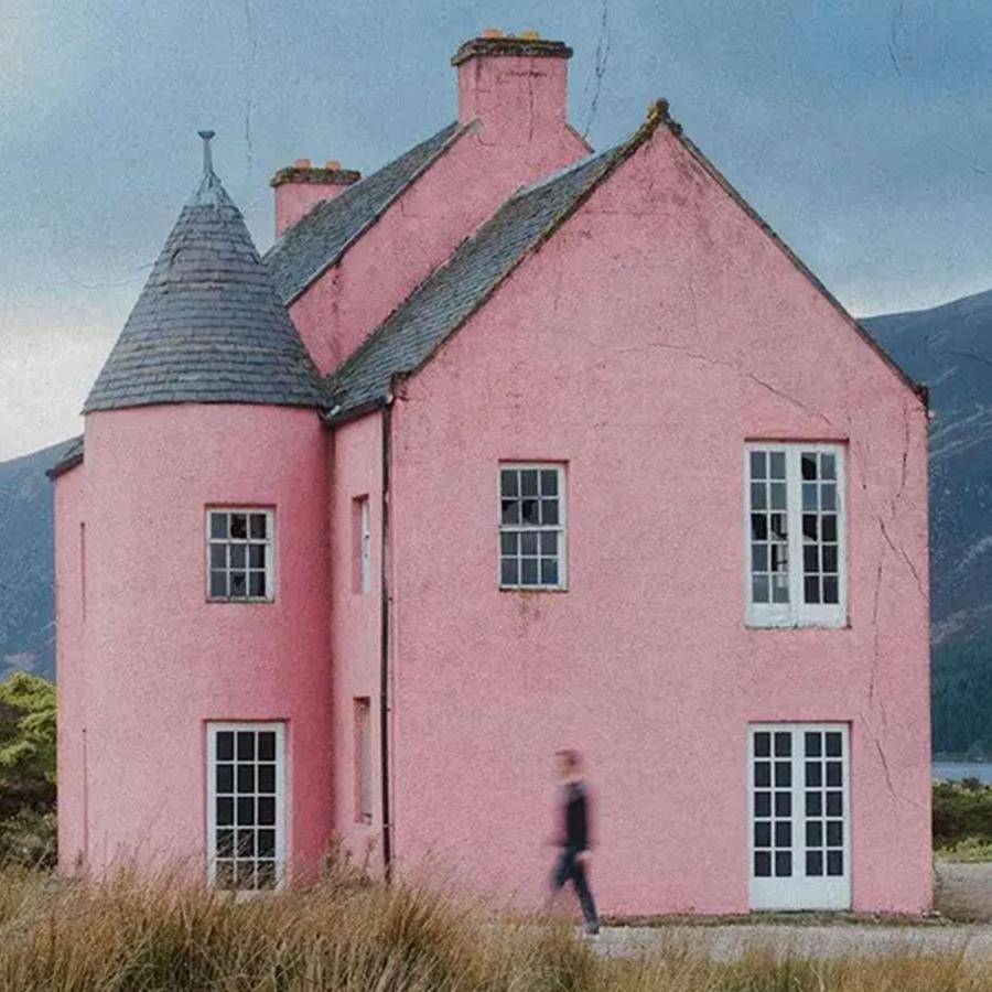 Composer Gareth Williams walking past the pink house at Loch Glass, Scotland.
