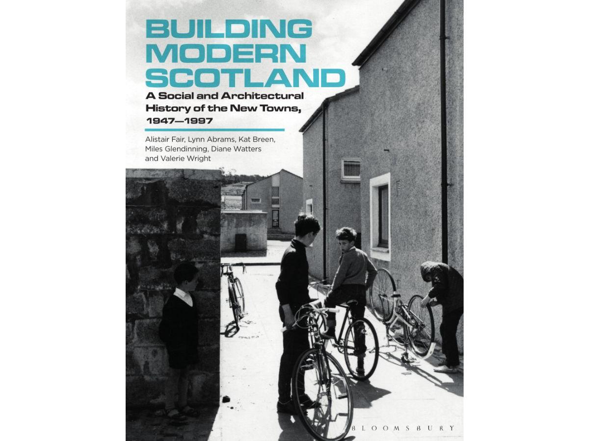 The front cover of Building Modern Scotland - a photograph of mid century new build houses, and young people with bicycles outside