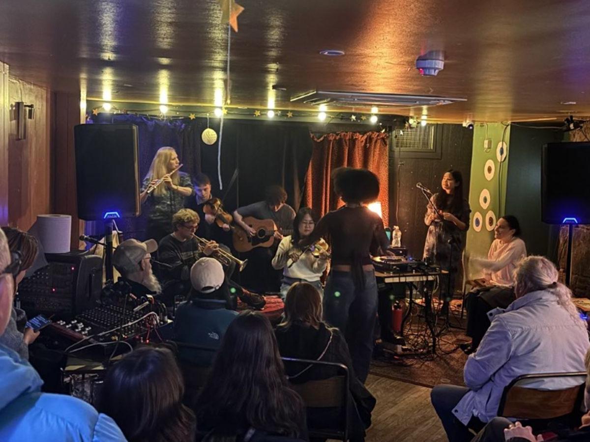 The musicians on stage, playing; the audience watching and listening