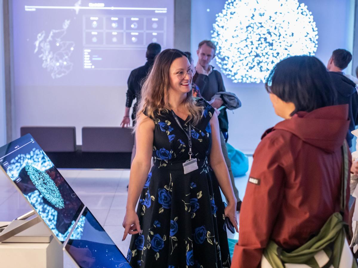 Image from the Design Informatics research project exhibition, Digital Ghosts (held at Inspace, November 2025), showing Dr Andrea Kocsis (IDI - ECA) discussing data visualisations of the Scottish National Web Archives, developed with Dorsey Kaufman (IDI – Informatics) and master's students. Image credit: Chris Scott, 2025