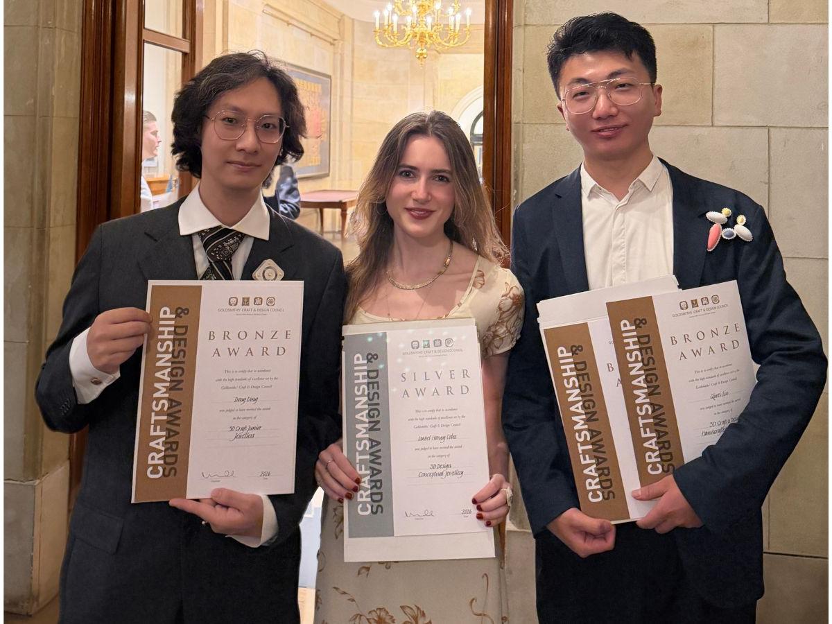 Dong, Isabel and Mervin, smartly dressed, hold their certificates