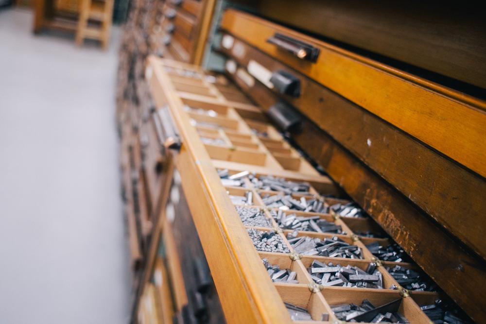 Drawers showing metal letters and numbers that can be used as part of the printmaking process