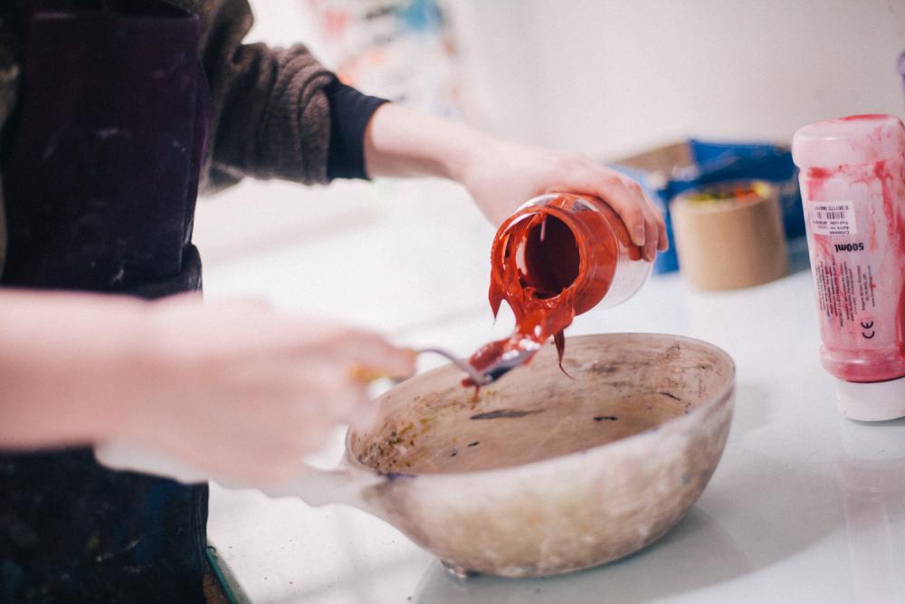 Paint being poured into a bowl
