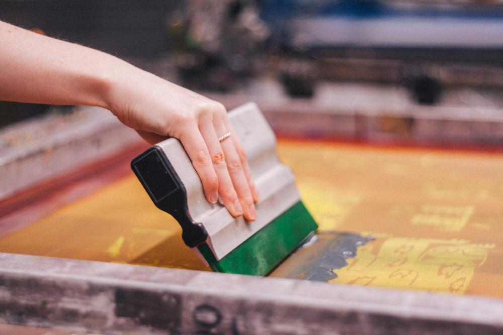 A student working with equipment in the printmaking studio