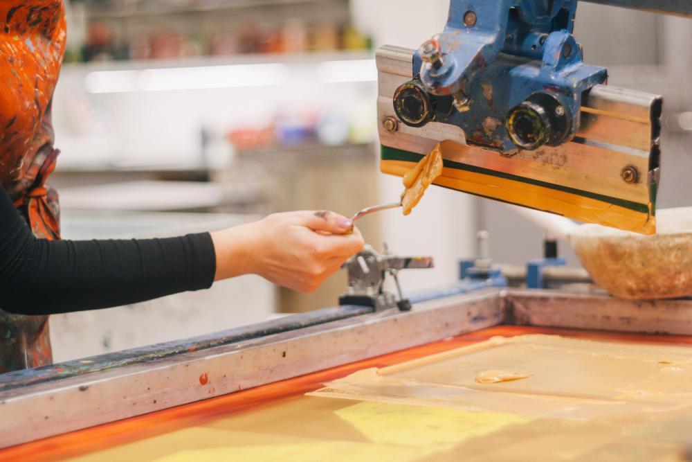A student working with equipment in the printmaking studio