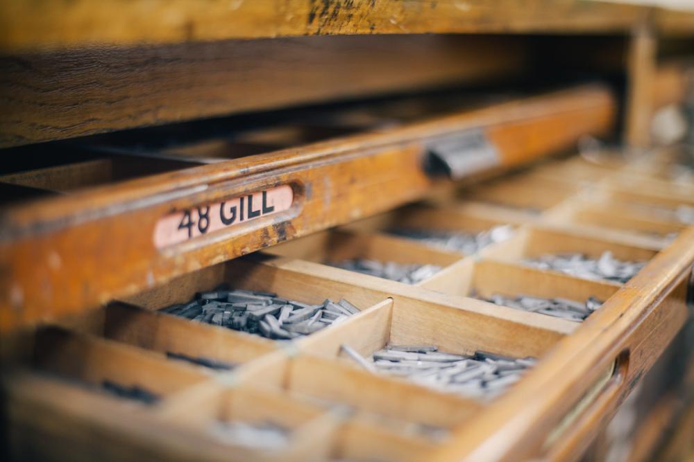 Drawers showing metal letters and numbers that can be used as part of the printmaking process