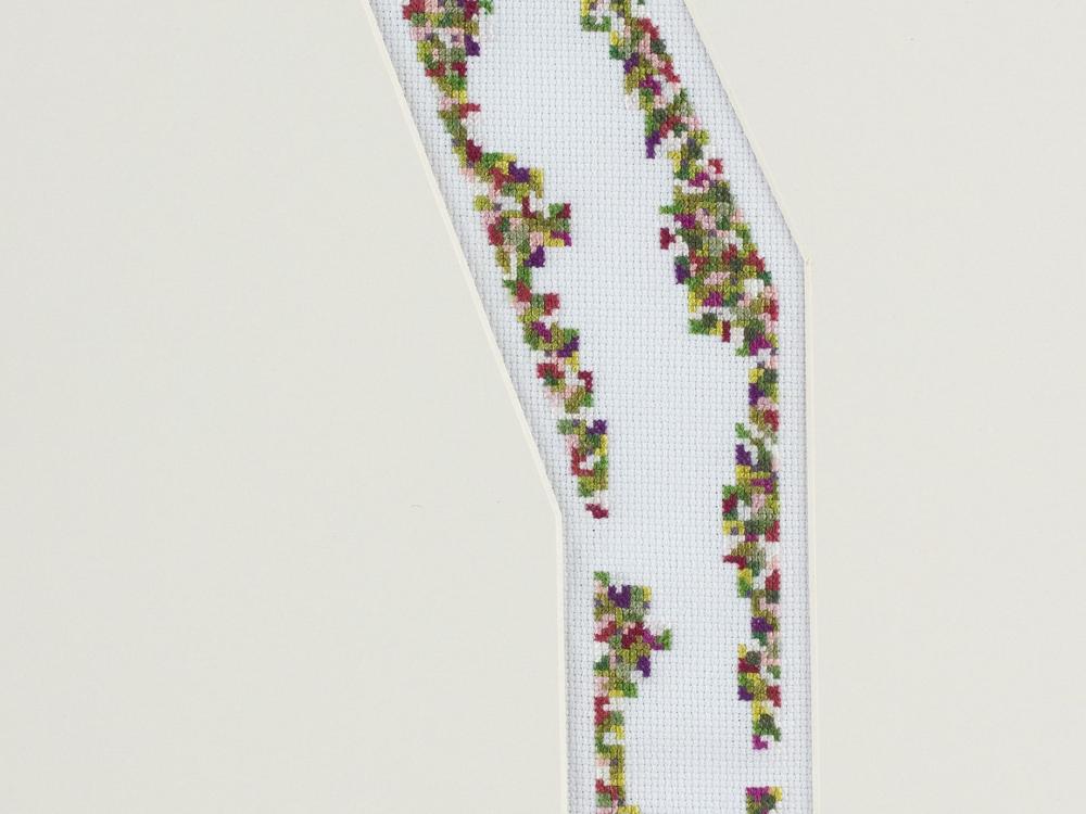 A cross-stitch suggesting a pathway lined either side by plants and greenery.