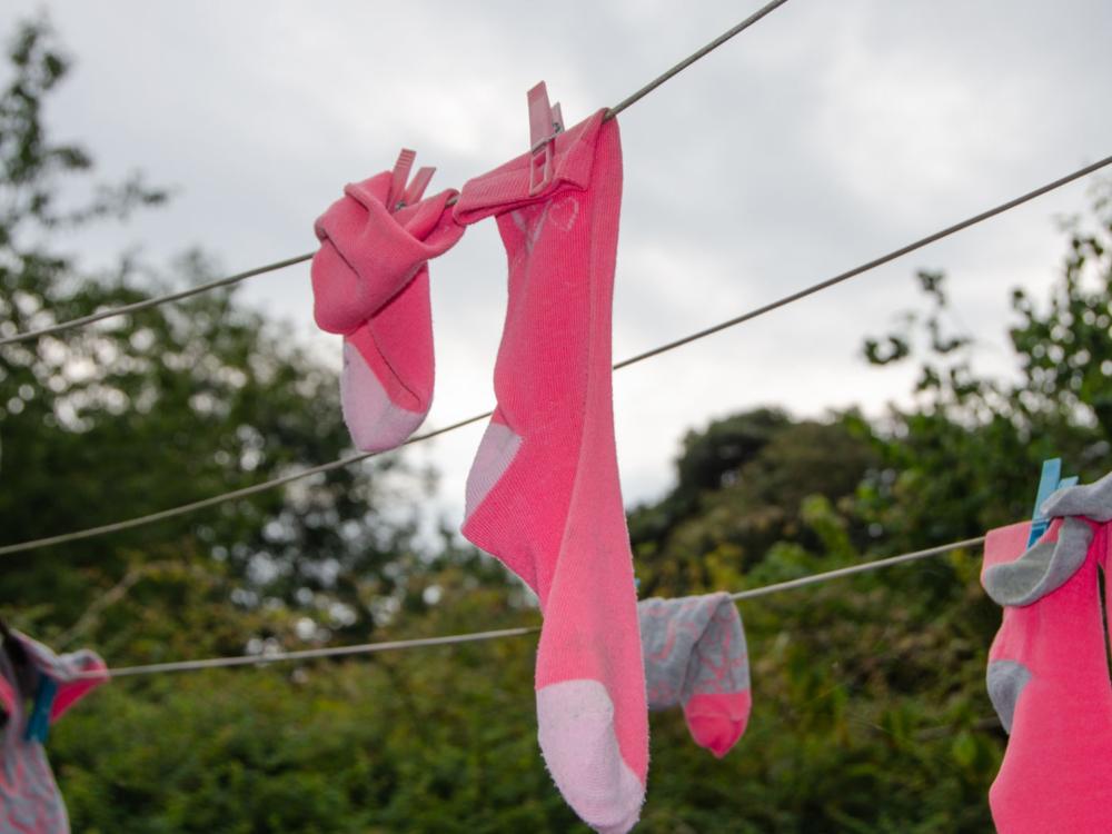 Pink socks hung on a drying line.