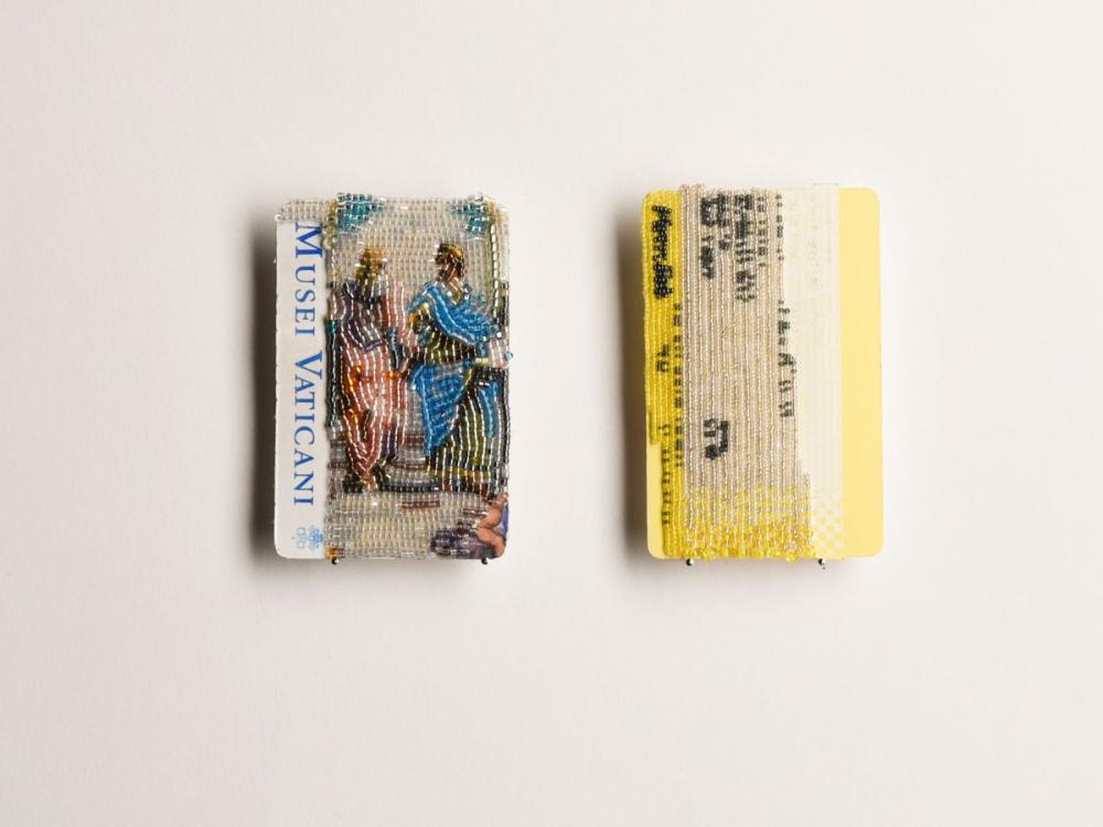 Two paper tickets - one for the Vatican and one a rail ticket - which have had their designs partially recreated on top of the paper with fine beadwork