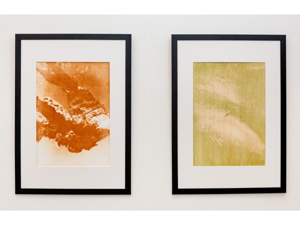 Two prints, in black frames. The images are abstract, in orange/yellow shades