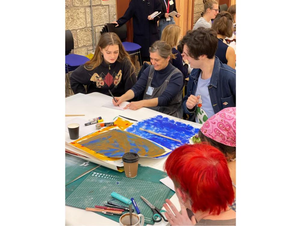 Several illustrators working together at a table, talking and smiling