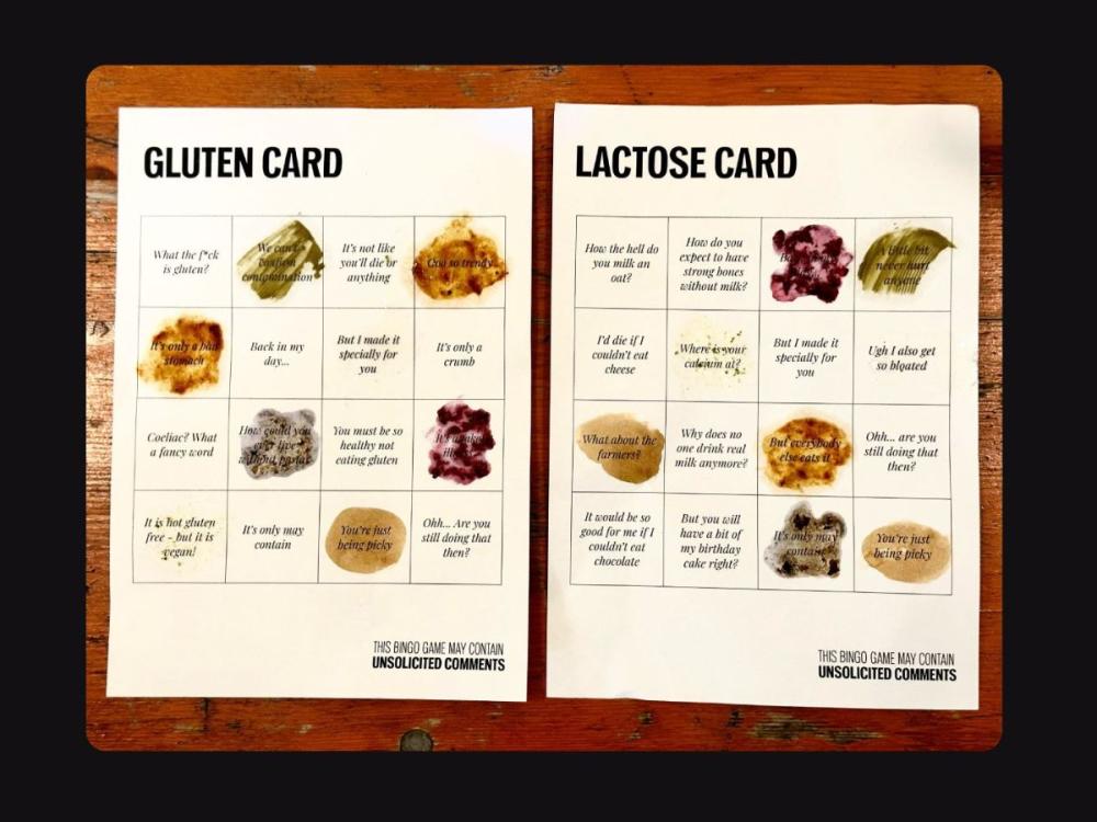 Two mock up bingo cards, mostly black and white but with some coloured images which could be smears of foodstuffs. One is headed 'Gluten card', the other 'Lactose card'. Each has a grid of 4x4 squares, each containing an unsolicited comment, such as "Back in my day..." or "I'd die if I couldn't eat cheese"