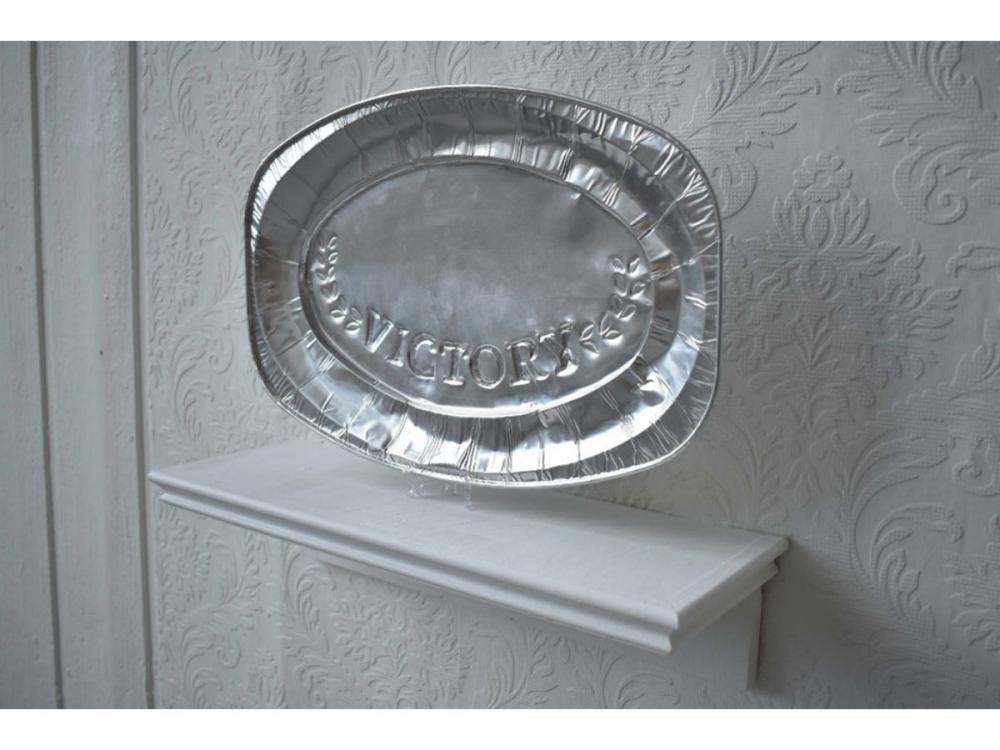 An aluminium serving dish, on a white shelf. The word Victory is pressed into it, with a laurel pattern either side.