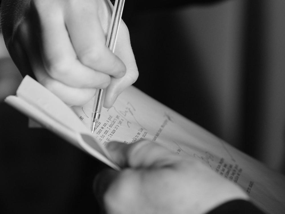 Close up of hands holding a script and making annotations in pen