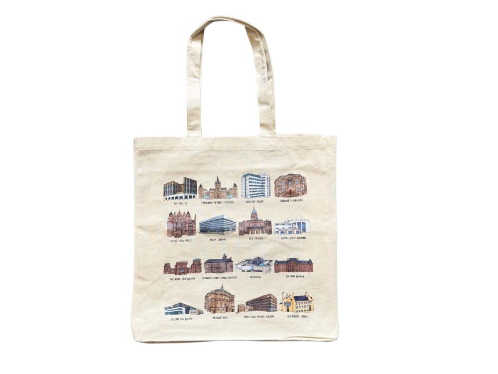 A white tote bag, featuring 16 of the illustrations 