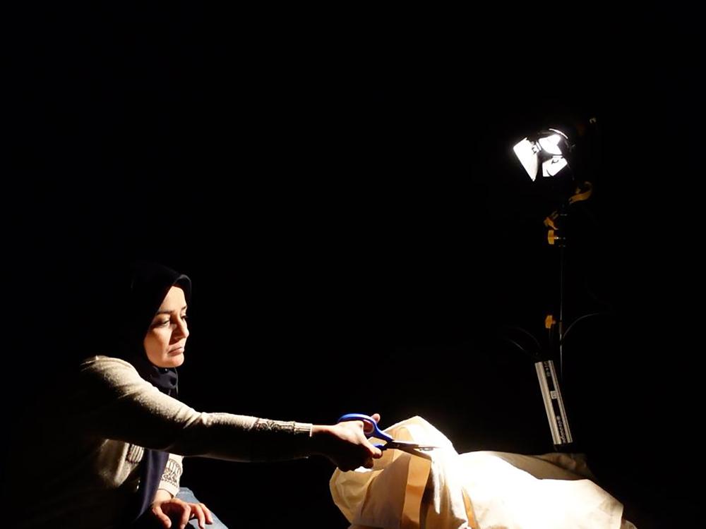 Student in TV studio cutting fabric for a film shoot