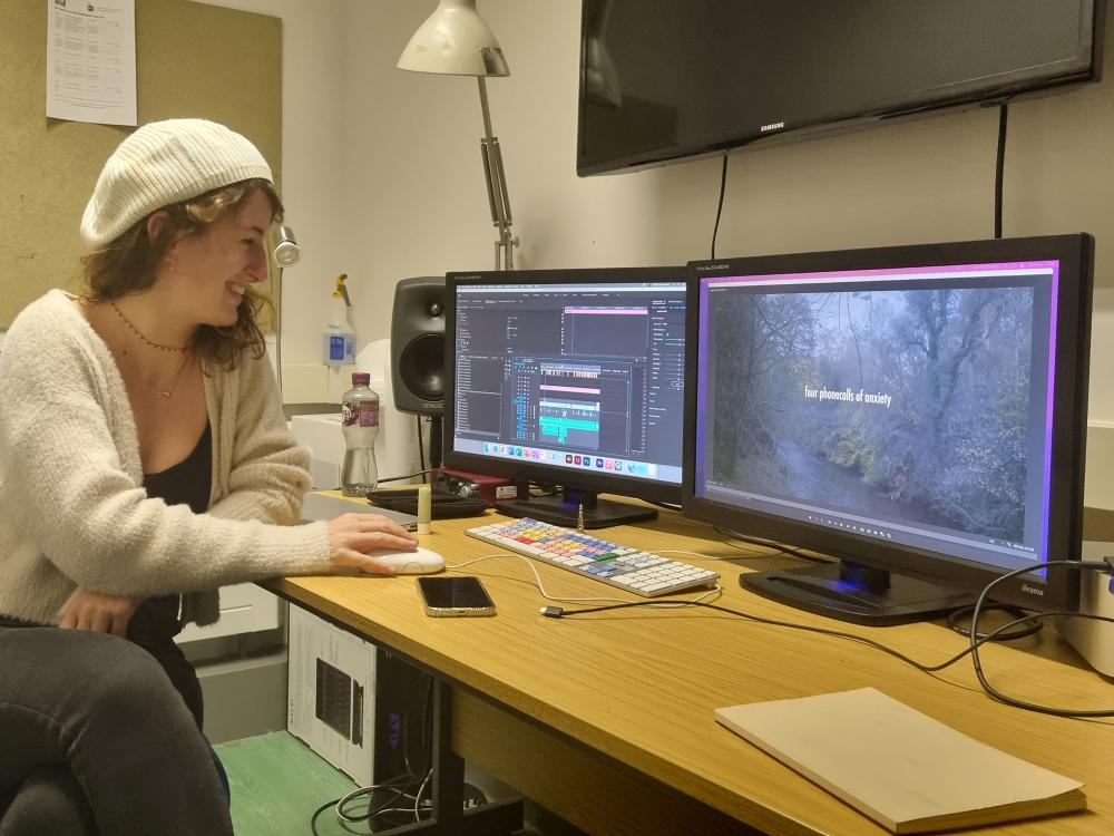Student editing graduation film in editing suite