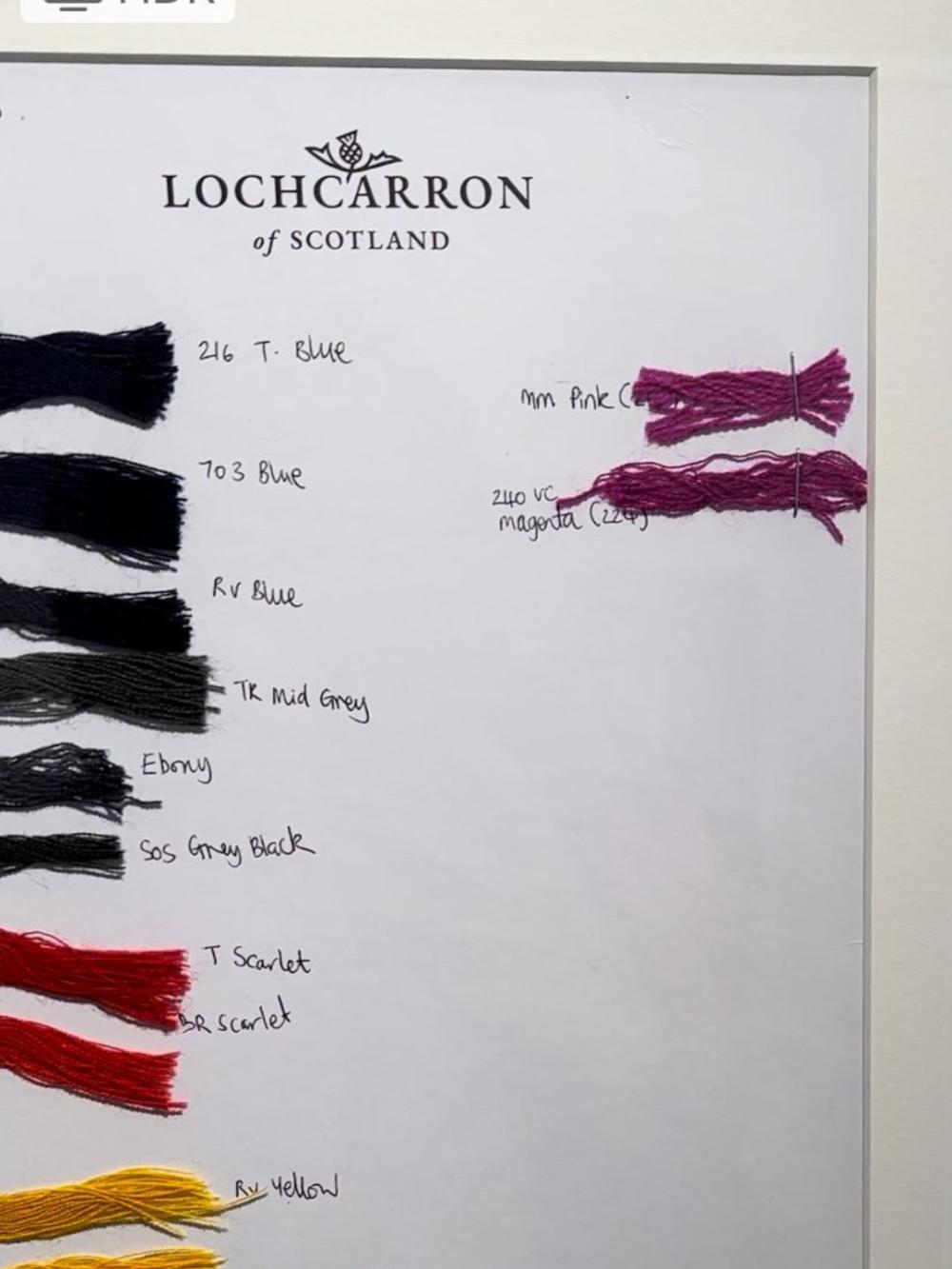 Skeins of thread in each of the tartan colours, on a white board, with the name of the colour written next to it. A Lochcarron of Scotland logo printed at the top.