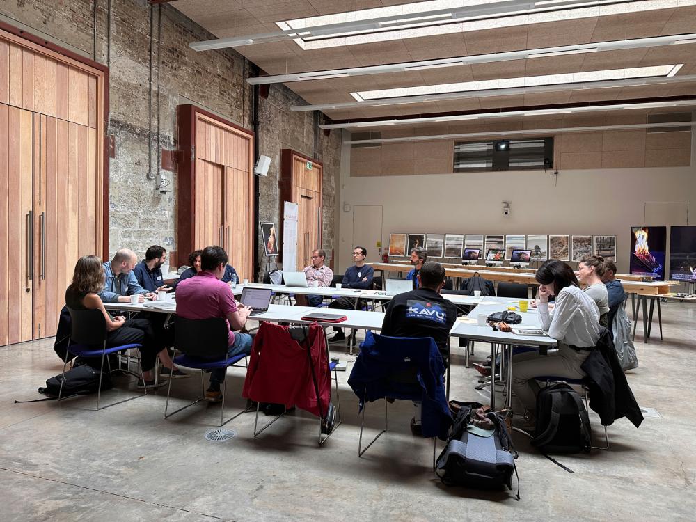 A group of people sitting around a table in the large events space, West Court at ECA.