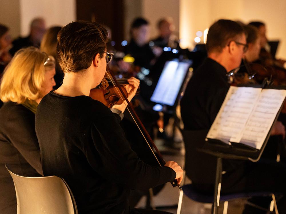 A violinist plays with the orchestra.