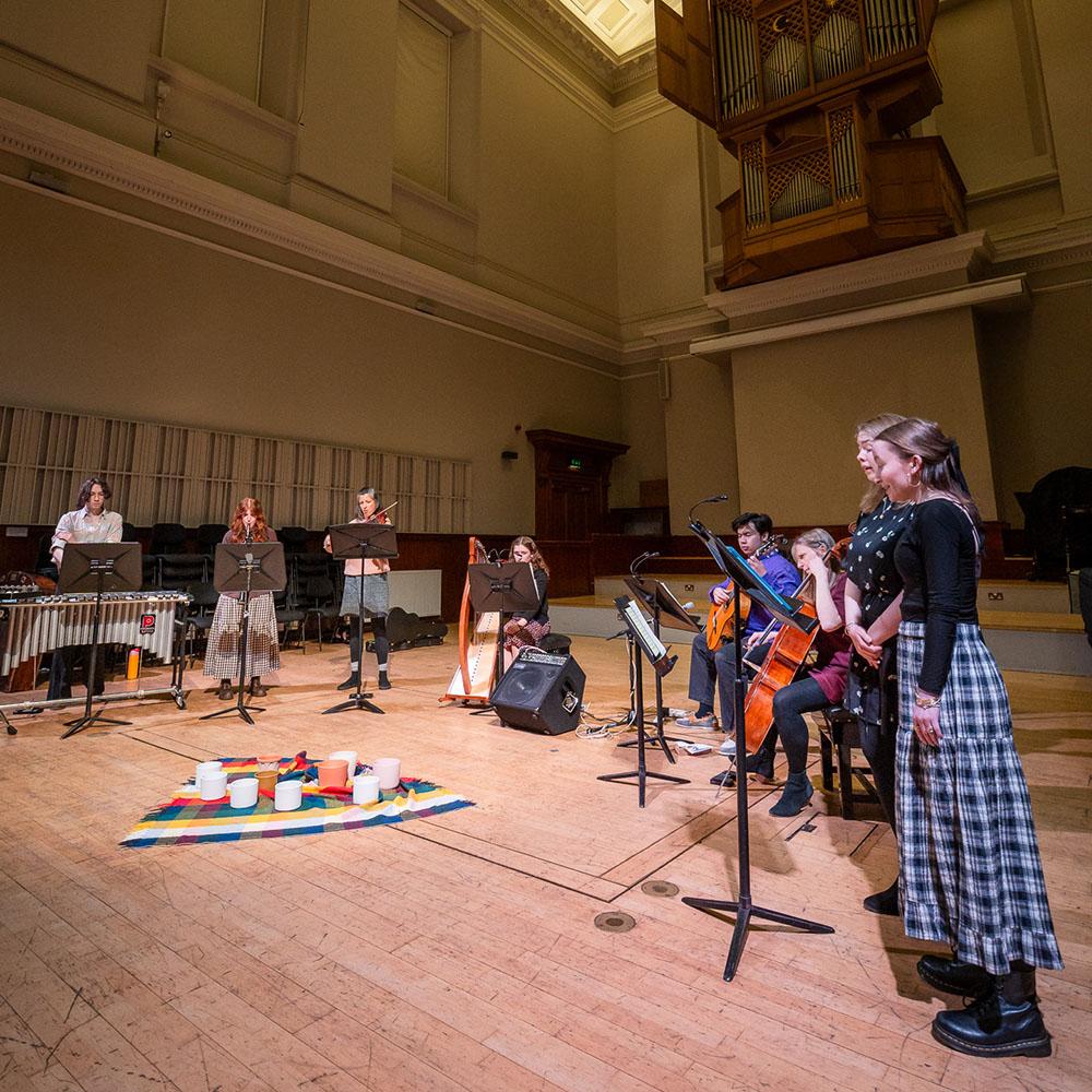 A group of singers are performing alongside a group of musicians.