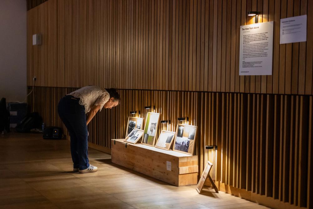 A visitor looking at artwork in the Authenticity Unmasked: Unveiling AI-Driven Realities Through Art exhibition space.