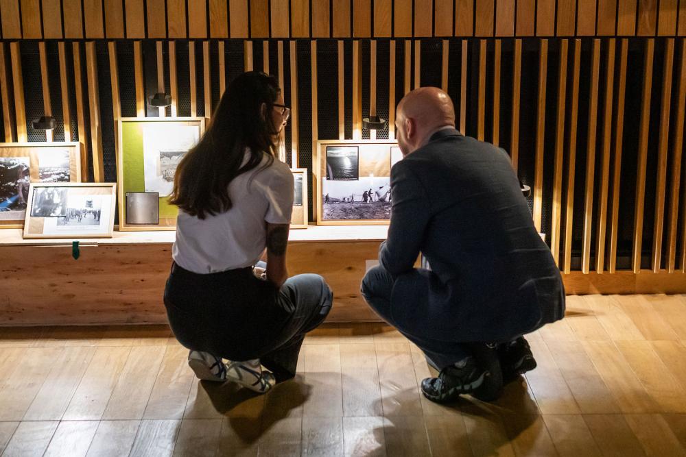 Two people looking at art work in the Authenticity Unmasked: Unveiling AI-Driven Realities Through Art exhibition space.