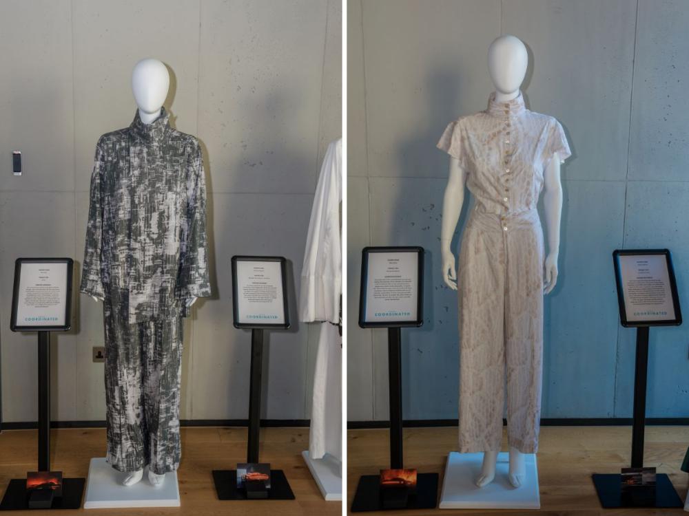 Two sets of garments on mannequins, each with trousers and a top. One has a black and white pattern; the other a lace-like pattern in white and grey.