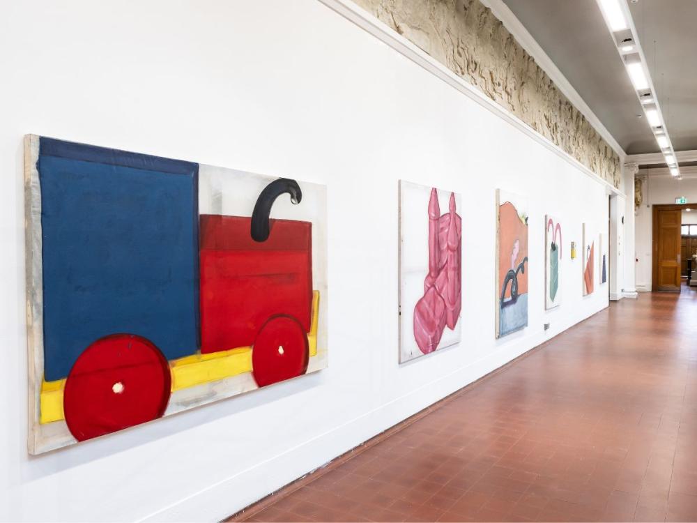 A series of paintings along the Sculpture Court balcony - bright, bold colours and shapes. The nearest is a toy train in blue, red, and yellow.
