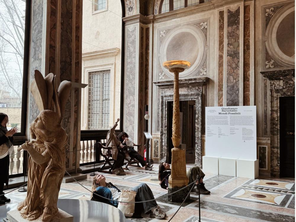 Two people lay on the floor of a Renaissance villa to see the painted ceiling. 