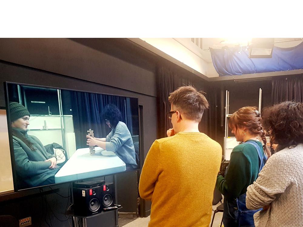 Cinematography tutor and students reviewing their camera exercise on a TV screen at the Camera Workshop 