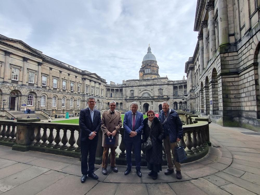 Emre Araci stands with his family and the Principal and Vice Chancellor of the university, at the corner of the Old College Quad.